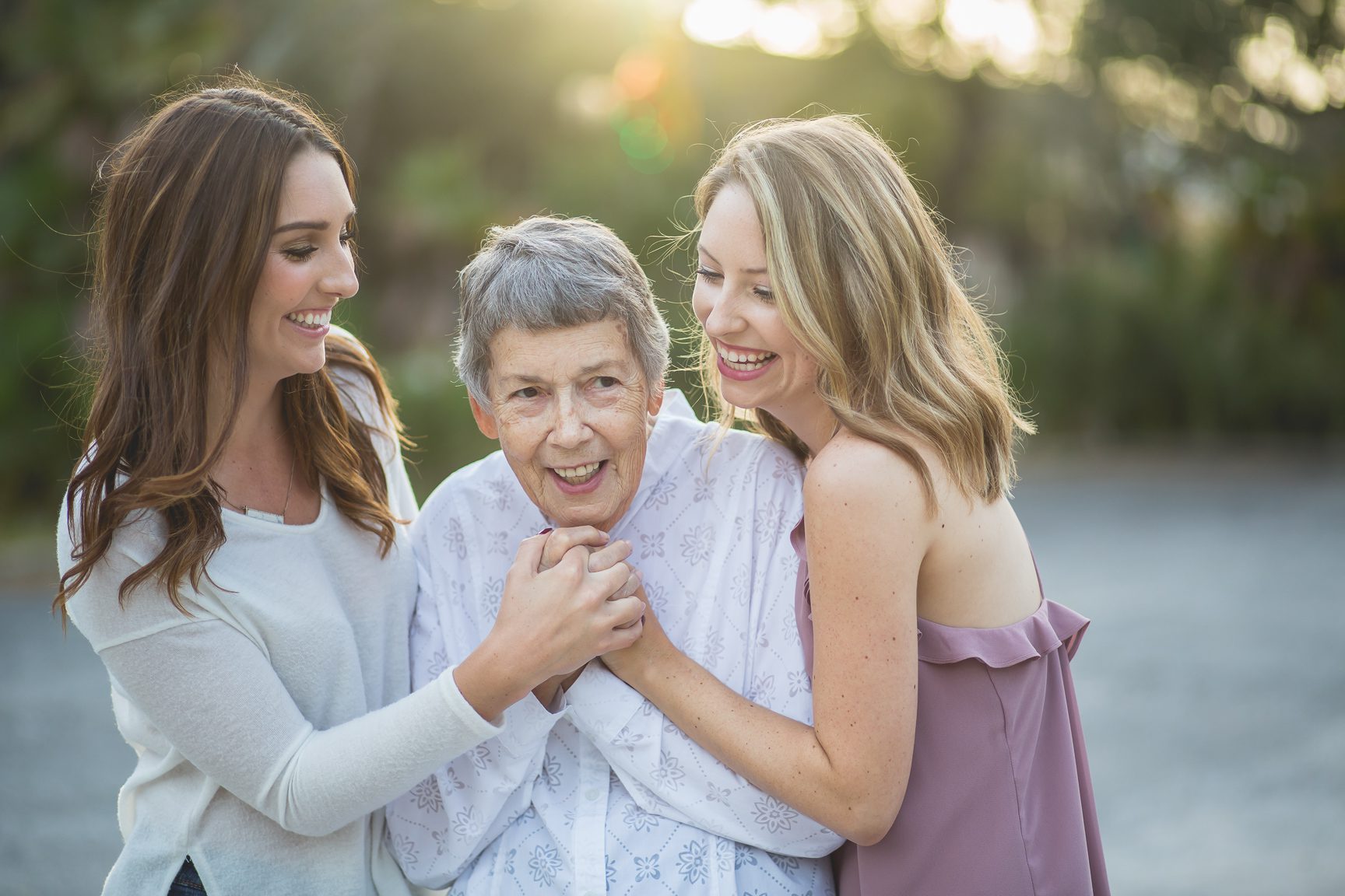 authentic family moment with two sisters and their grandmother at golden hour in St. Petersburg, FL