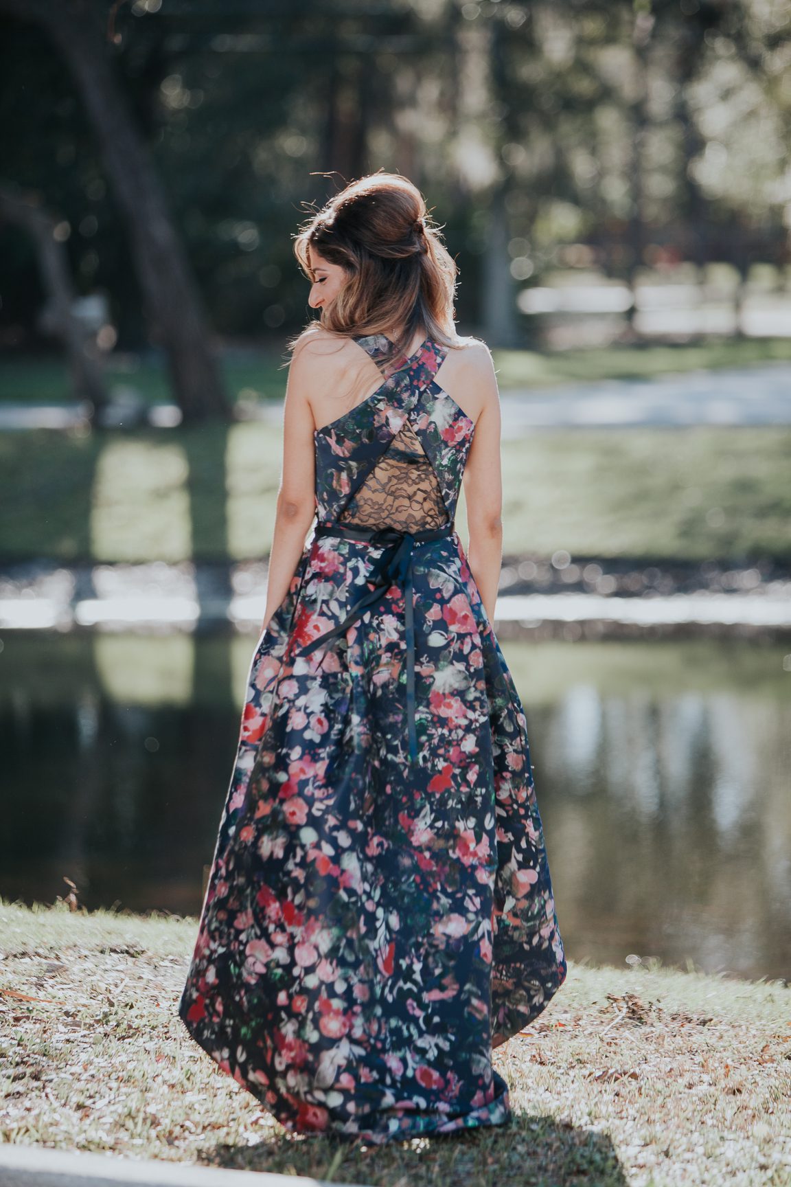 bride to be in flowered gown by lake