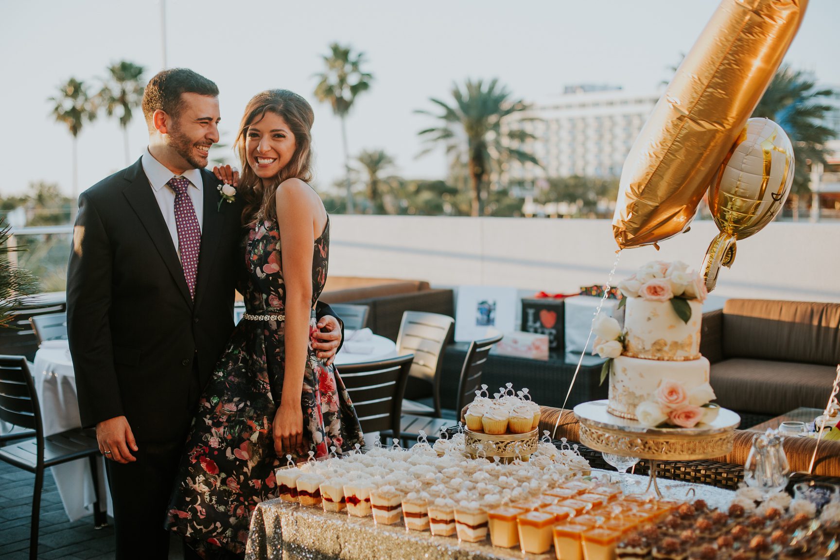 engaged couple with dessert table at engagement party