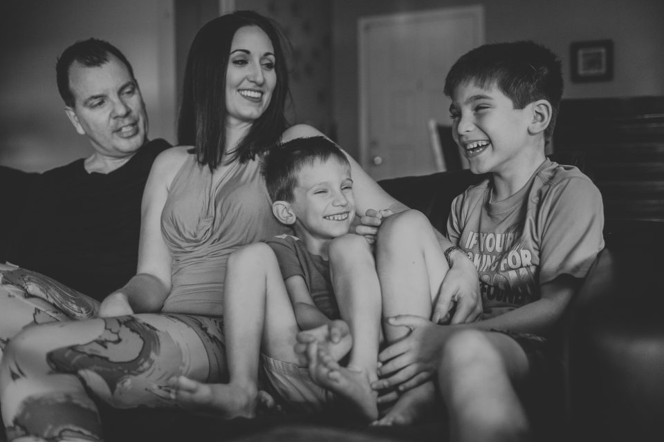 laughing family on the couch for in-home session