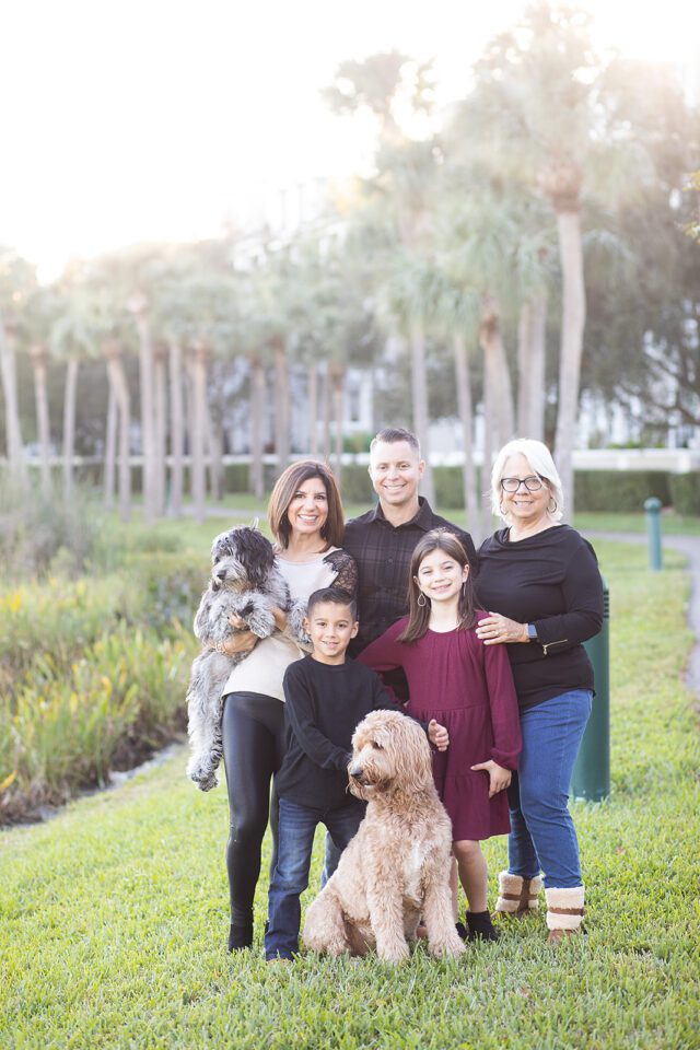 Larger family by lake in Tampa with golden doodle